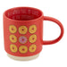 Red mug with donut designs and text on a white background