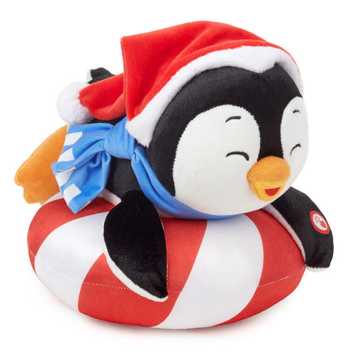 Plush penguin toy wearing a Santa hat and bow tie on a white background
