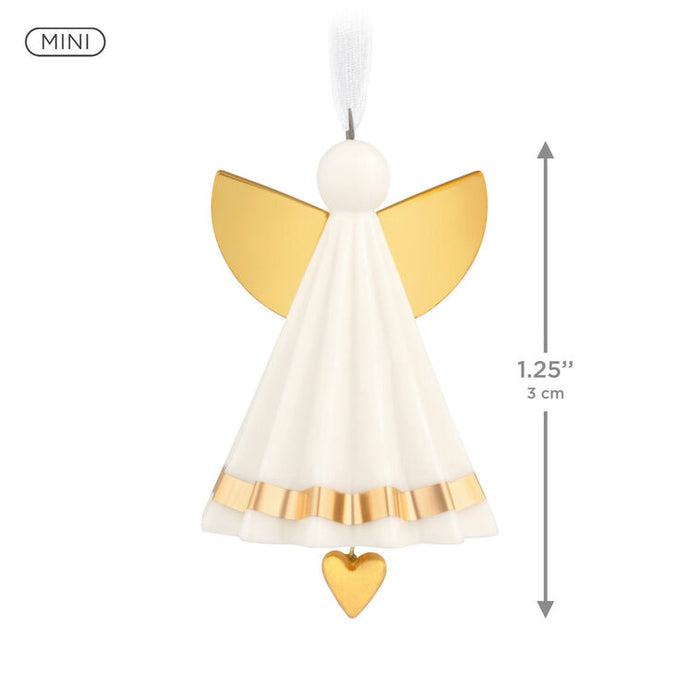 Miniature angel decoration with gold wings and a heart on a white background