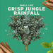 Text 'Smell Like Crisp Jungle Rainfall' with green foliage and dried leaves on a green background