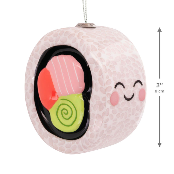 Decorative ornament shaped like a yin yang with sushi design inside, on a white background.