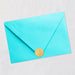 Turquoise envelope with a gold seal on a light gray background
