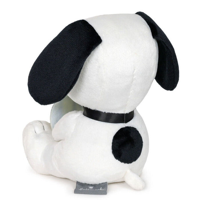 Plush toy resembling a black and white dog with a black collar on a white background