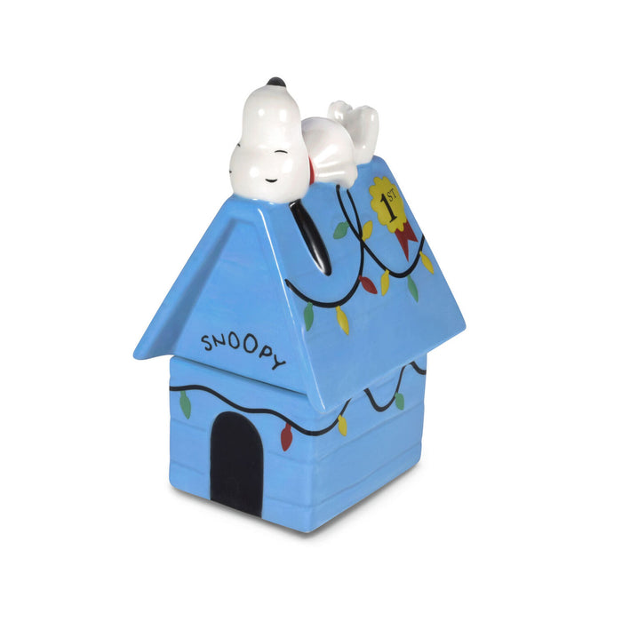 Snoopy doghouse toy with a white dog on top against a white background