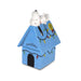Snoopy doghouse toy with a white dog on top against a white background