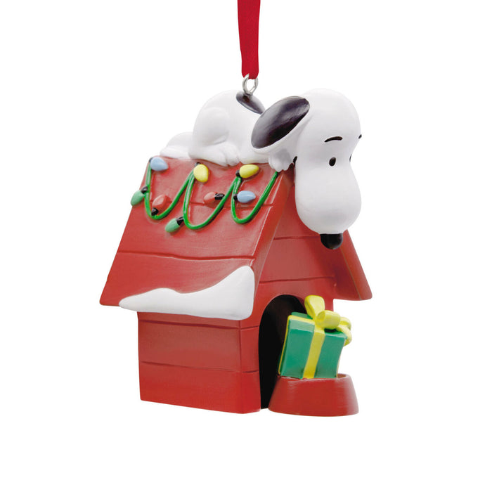 Snoopy Christmas ornament with doghouse, gift, and lights on a white background