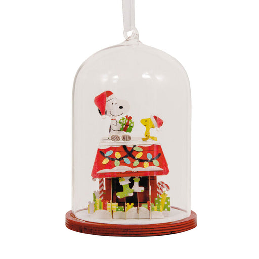 Christmas-themed ornament with a dog and a house under a glass dome on a white background