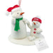 Hallmark 2026 Family Snowman Christmas ornament featuring a large white plush snowman with a red Santa hat and green scarf next to a smaller white plush snowman wearing a red 2026 hat, on a white base with a hanging tag.