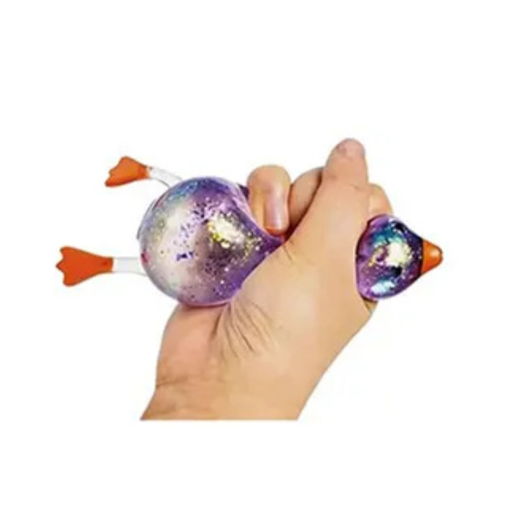 Hand holding a colorful, glittery toy resembling a duck on a white background