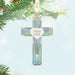 Decorative cross ornament with 'God is Love' message on a Christmas tree.