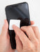 Person applying a white square sticker to a smartphone screen