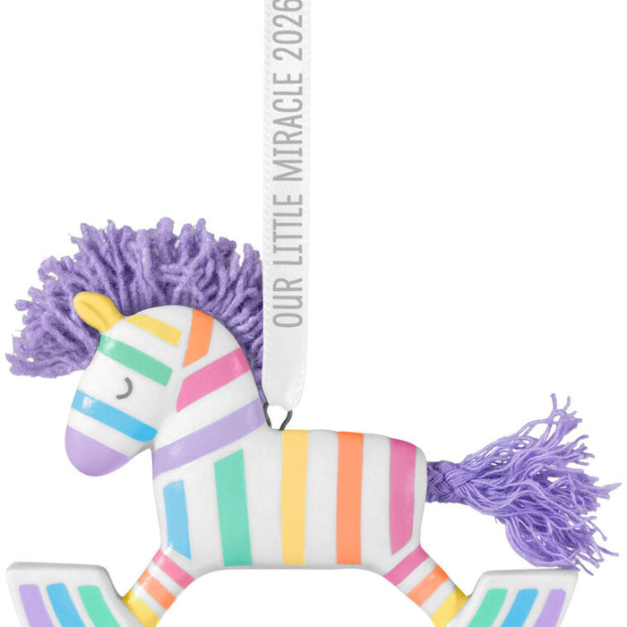 Colorful striped horse toy with a purple mane and tail on a white background.