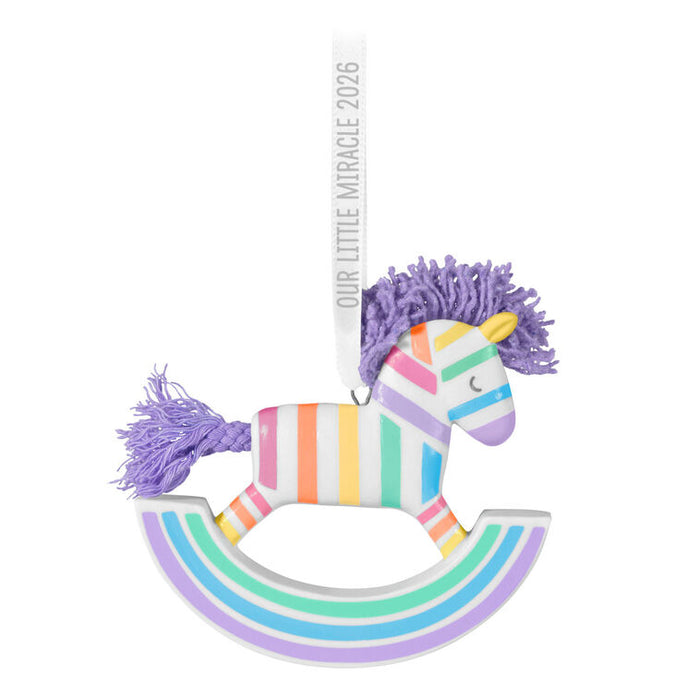 Colorful rocking horse toy with pastel stripes and purple hair on a white background
