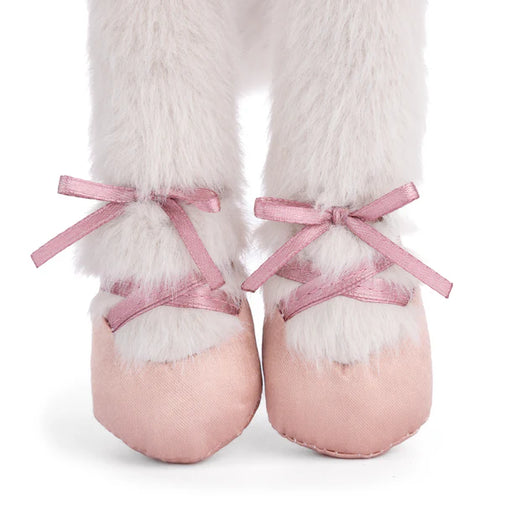 Pink ballet shoes with white fur and ribbons on a white background