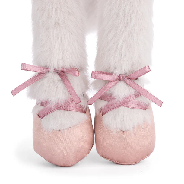 Pink ballet shoes with white fur and ribbons on a white background