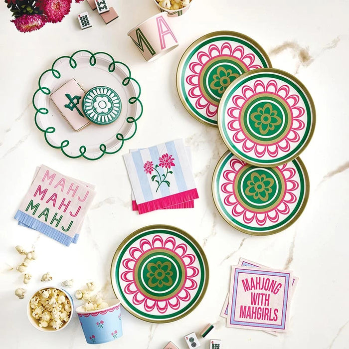 Colorful party plates, napkins, and cups with decorative patterns on a white surface.