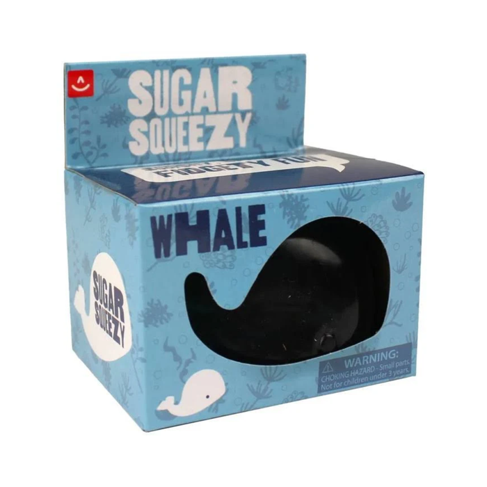Sugar Squezy Whale toy in its original blue packaging box, featuring a clear window that shows the black whale-shaped toy inside.
