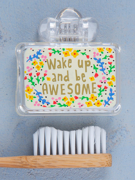 Toothbrush with a holder containing a motivational quote and colorful design on a blue background