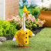 Goose wearing a yellow raincoat and hat in a garden setting