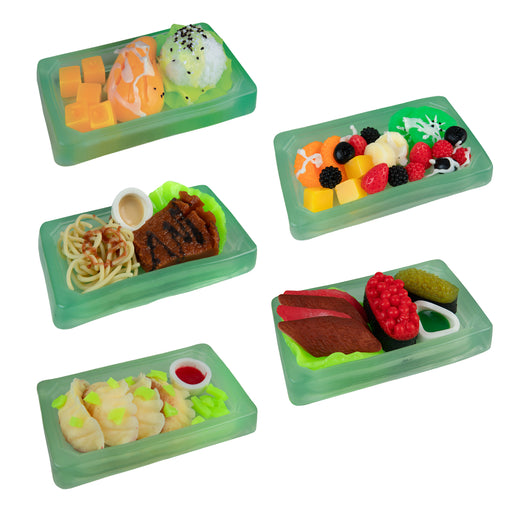 Set of miniature food items in green trays on a white background