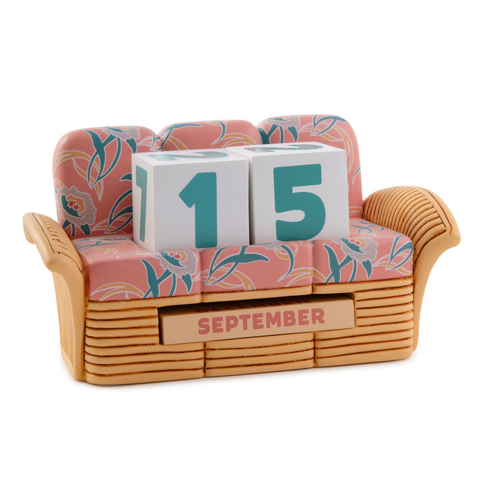 Decorative calendar with 'September 15' displayed on a floral-patterned couch.