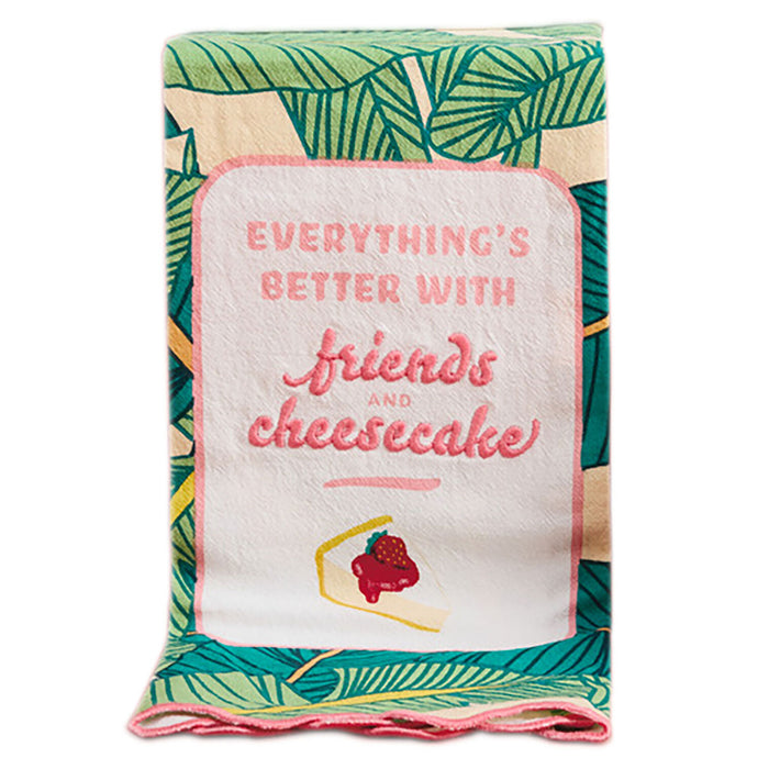 Fabric with leaf pattern and text 'Everything's better with friends and cheesecake' on a white background