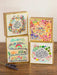 Set of four colorful greeting cards with motivational phrases on a wooden surface.