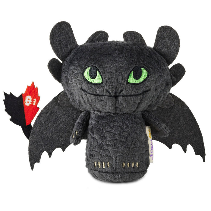 Plush toy resembling a dragon with green eyes on a white background