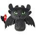 Plush toy resembling a dragon with green eyes on a white background