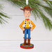  Woody Christmas ornament from Toy Story hanging on a tree branch.