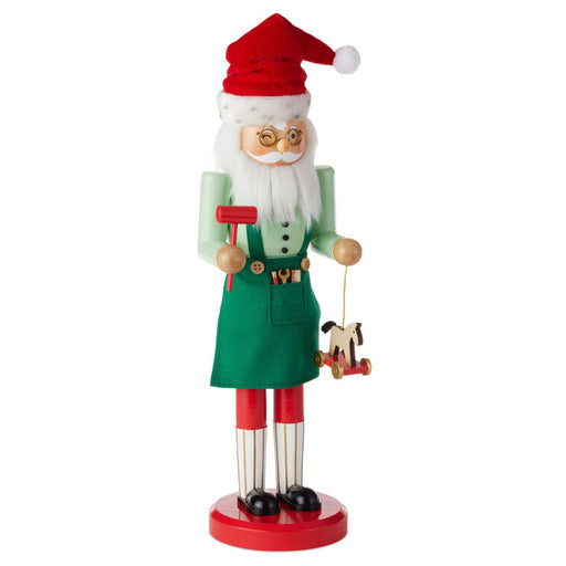 Christmas nutcracker figurine of a Santa Claus holding a dog toy on a white background