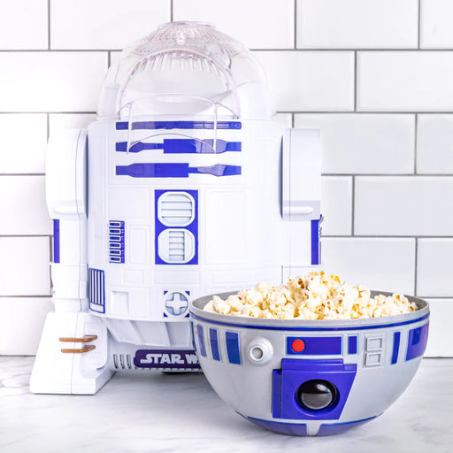 R2-D2 popcorn maker with a bowl of popcorn on a white tiled background