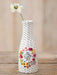 Decorative bottle vase with floral design and text on a wooden surface