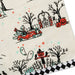 A close-up of a Halloween-themed fabric or paper product featuring a cream background with printed black trees, a red convertible, skeleton driver, pumpkins, ghosts, and a black-and-white checkered border.