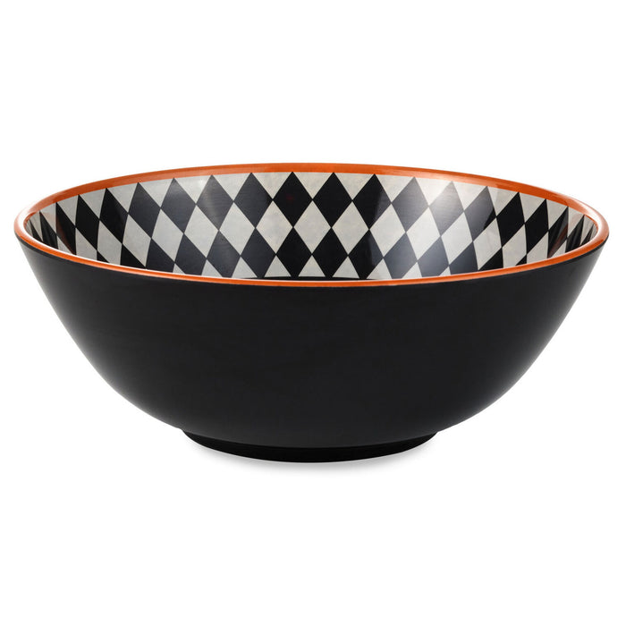 A black ceramic bowl with a black and white harlequin diamond pattern on the interior rim and a thin orange-red edge accent.