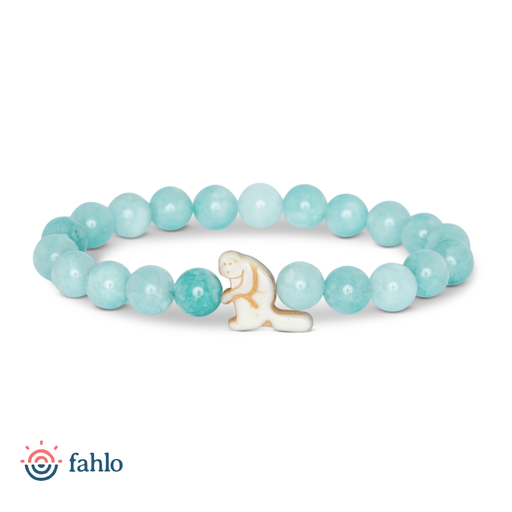 A beaded stretch bracelet featuring light blue-green round beads and a small white ceramic seal charm with gold detailing, shown on a white background with the fahlo logo in the bottom-left corner.