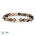 A beaded stretch bracelet featuring round brown and beige marbled beads with a small white polar bear charm outlined in gold, displayed on a clean white background with the 'fahlo' brand logo in the bottom-left corner.