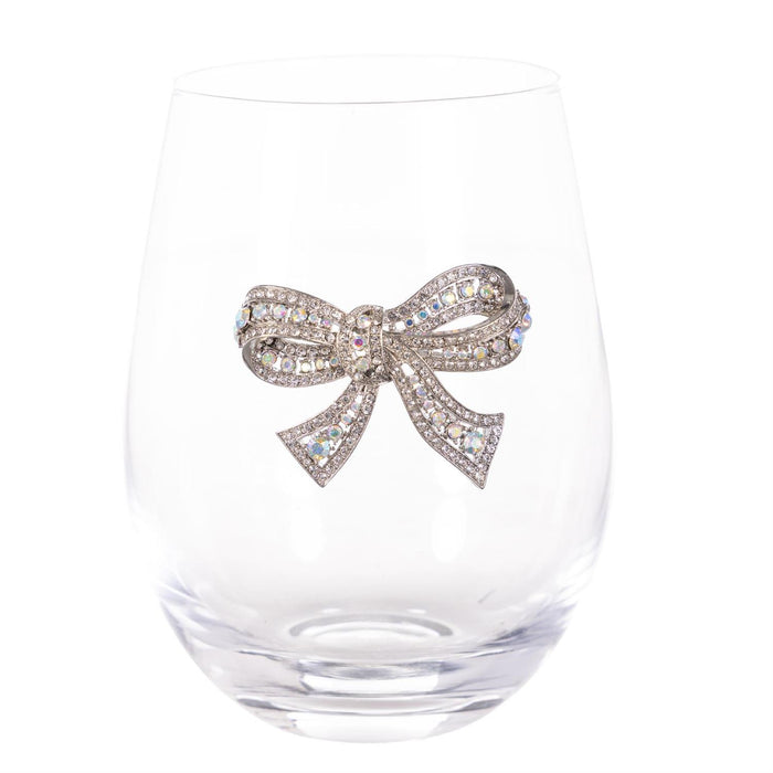 A clear stemless wine glass with a decorative silver bow embellished with sparkling clear rhinestones, shown against a solid white background.