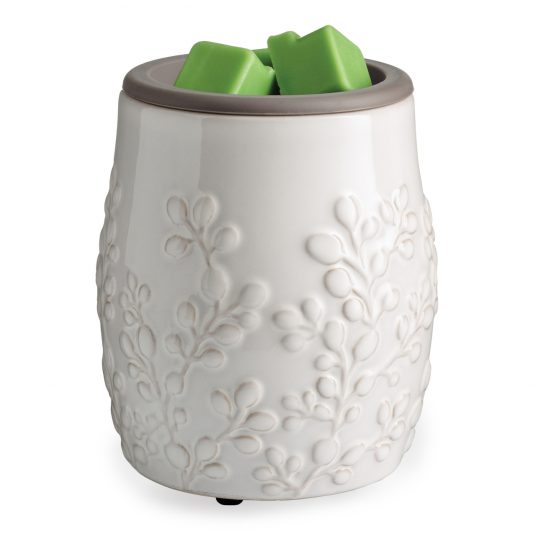 White wax warmer with green wax cubes on a white background