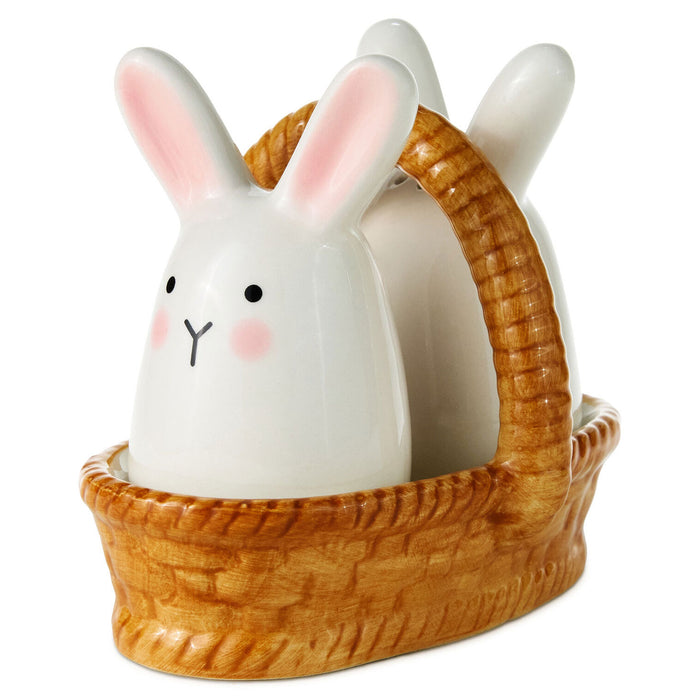 Ceramic rabbit figurine inside a woven basket on a white background