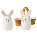 Two white ceramic rabbit-shaped containers with a wicker basket on a white background