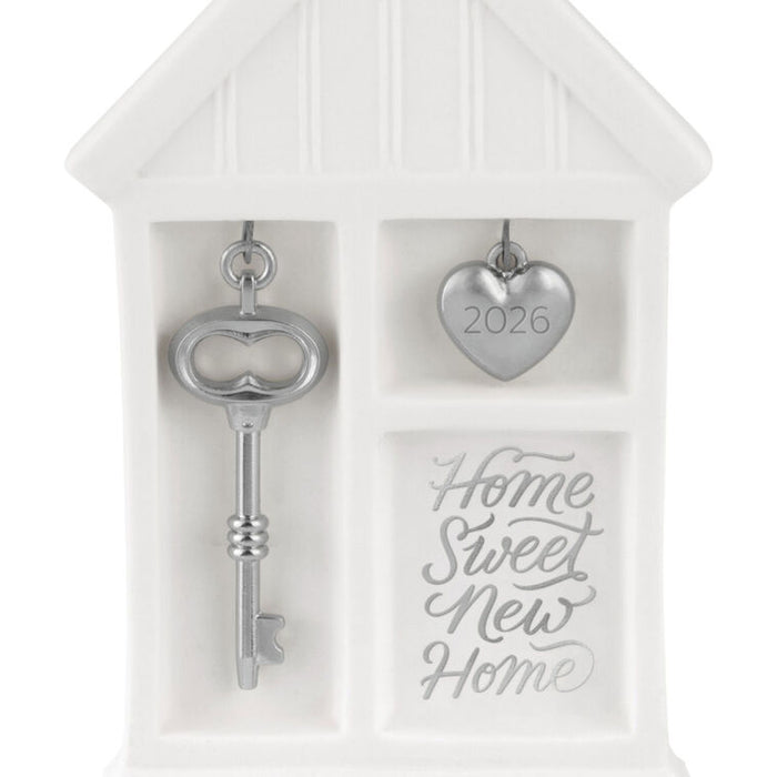 Decorative key and heart charm set in a white house-shaped box with 'Home Sweet New Home' text.