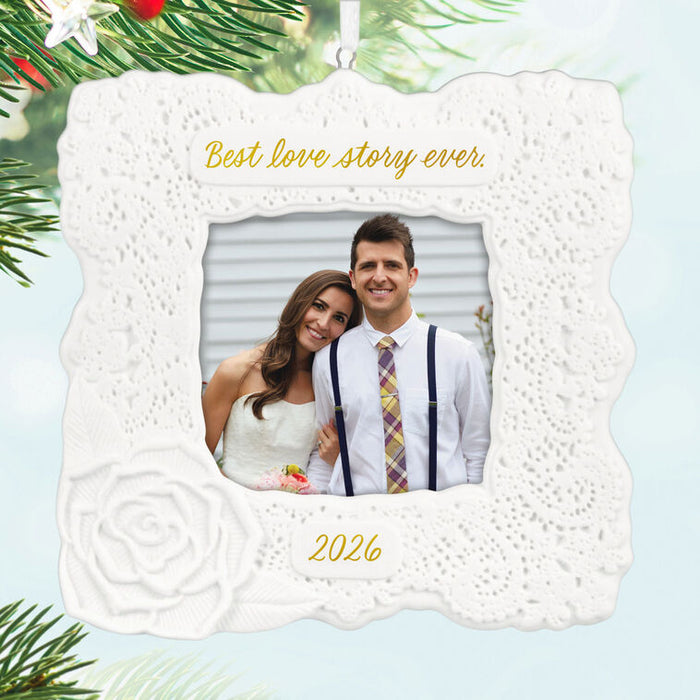Decorative ornament with a couple's photo and 'Best love story ever' text, surrounded by Christmas tree branches.