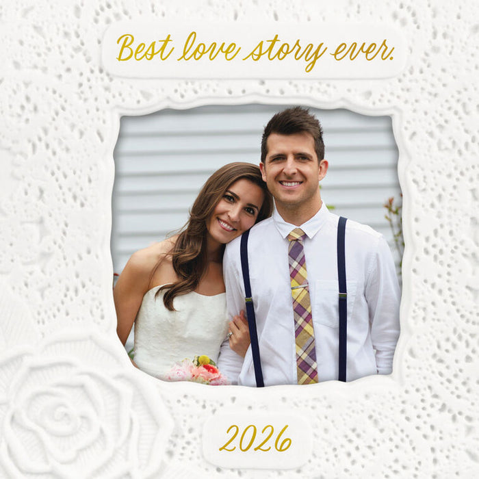 Couple in wedding attire with 'Best love story ever' text and '2026' on a textured white background