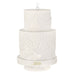 Two-tiered white cake ornament with intricate patterns and '2026' on a white background