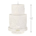White textured cake-shaped ornament with '2026' on a white background
