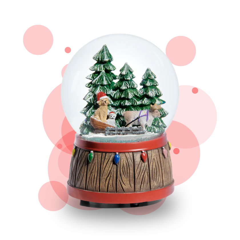 Christmas-themed snow globe with trees, a bear, and a sled on a white background.