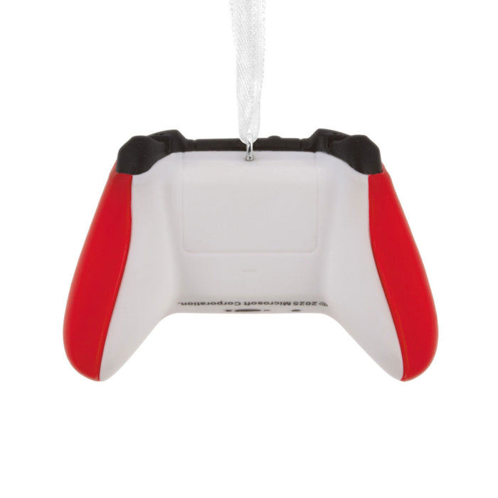 A novelty Christmas ornament shaped like a white video game controller with red side grips and black top accents, hanging by a clear ribbon on a white background.