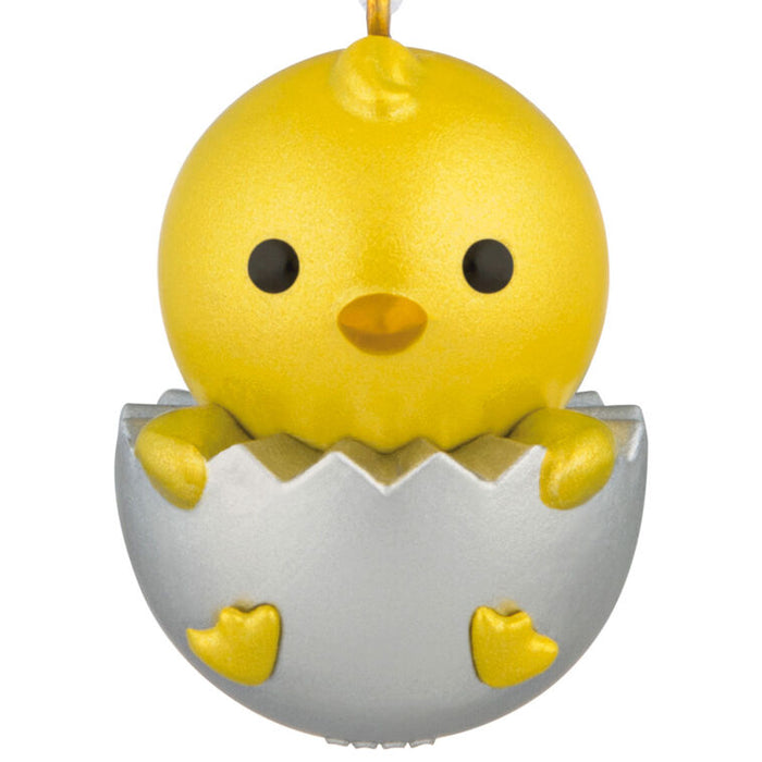 Yellow chick figurine hatching from an egg on a white background