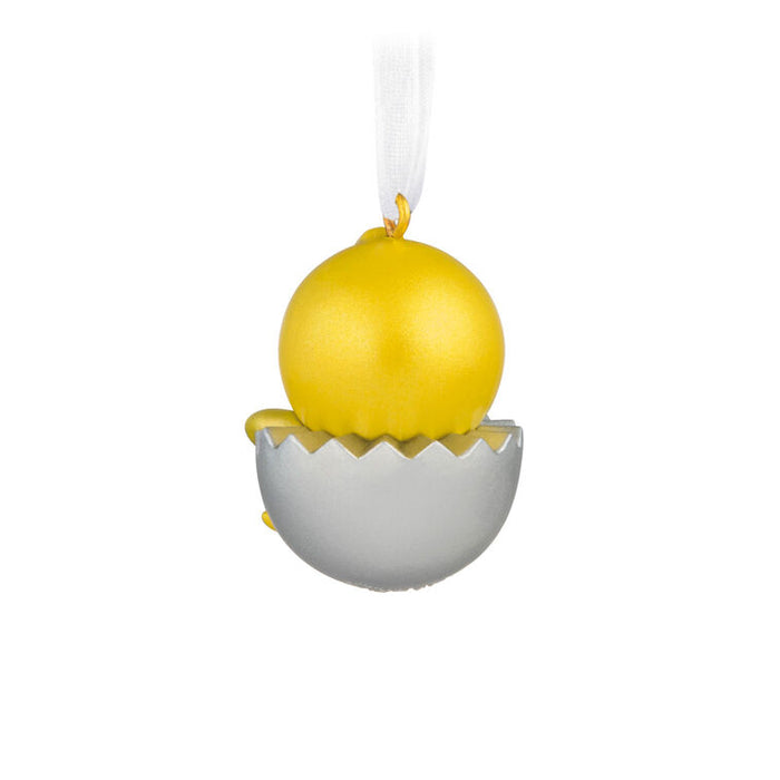Decorative ornament with a yellow sphere inside a cracked white shell on a white background